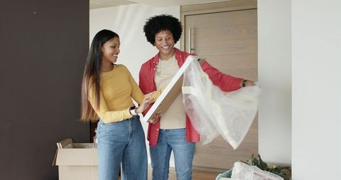 Friends Unpacking Home Decor Together in Natural Light