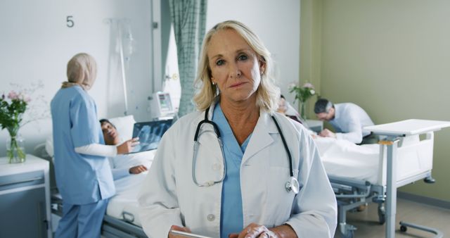 Senior Caucasian woman doctor stands confidently in a hospital. Her experience is evident in the busy medical environment around her.