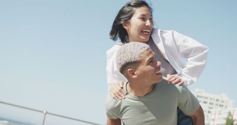 Joyful Couple Playfully Bonding at Sunny Seaside Promenade