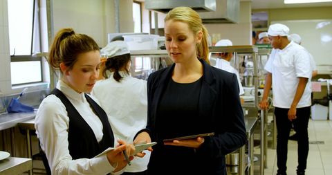 Female Managers Discussing in Industrial Restaurant Kitchen