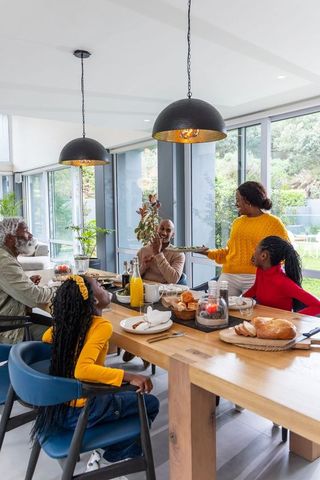 African American Family Sharing Breakfast Around Modern Dining Table with Garden View