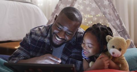 Joyful Father and Daughter Bonding with Tablet at Home