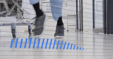 Medic walking through hospital corridor in scrubs and sneakers with data overlay