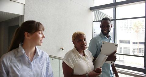Diverse team walking through modern office discussing projects
