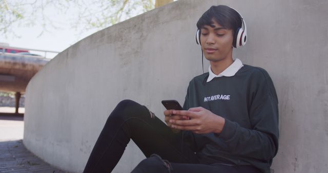 Young Man Relaxing Outdoors in Headphones, Listening to Music on Smartphone - Download Free Stock Images Pikwizard.com