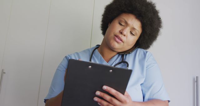 Nurse multitasking on phone while reviewing medical chart in hospital - Download Free Stock Images Pikwizard.com