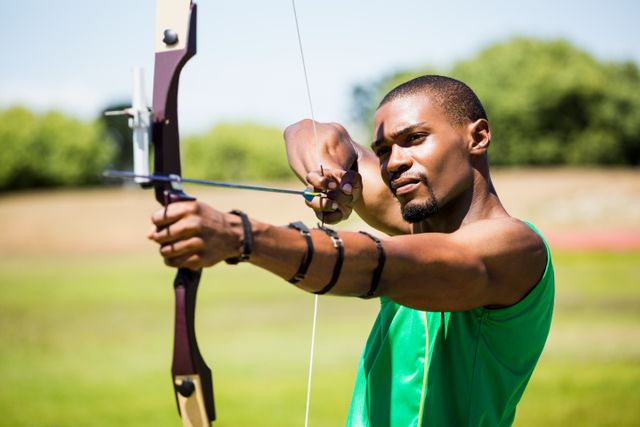 Athlete honing archery skills in an outdoor stadium, symbolizing focus, precision, and dedication. Ideal for content on sports training, athleticism, competitions, and determination.