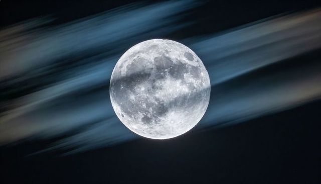 Glowing Full Moon Revealing Detailed Craters and Streaking Cirrus Clouds