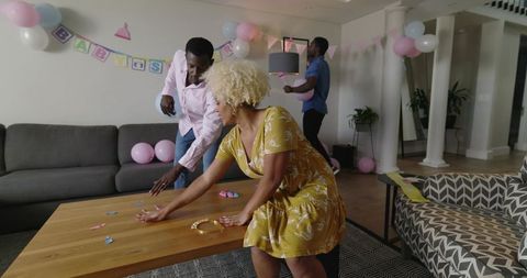 Friends Decorating Living Room for Baby Shower, Woman in Yellow Dress Arranging Favors
