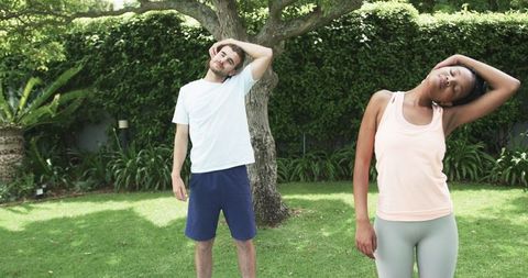 Diverse Individuals Stretching Outdoors in Lush Garden Setting