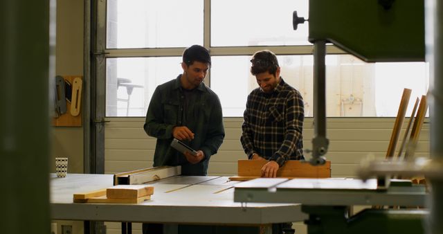 Two Male Workshop Workers Discussing Woodworking Project - Download Free Stock Images Pikwizard.com