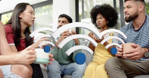 Group of friends chatting over coffee on sofa with wi-fi connectivity icons overlay