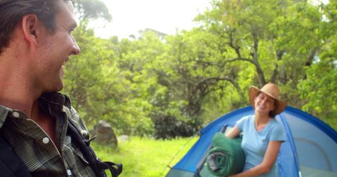 Couple Camping amidst Lush Greenery Enjoy Conversation
