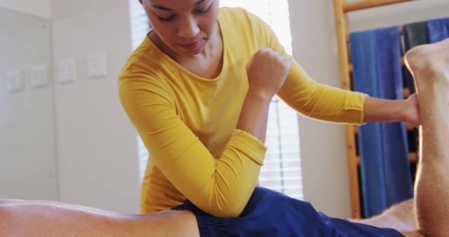 A physiotherapist performing muscle therapy on a patient's leg highlights the professional care and attention provided in physical therapy. Suitable for health and wellness blogs, medical and healthcare websites, physical therapy promotional materials, and rehabilitation center advertisements.