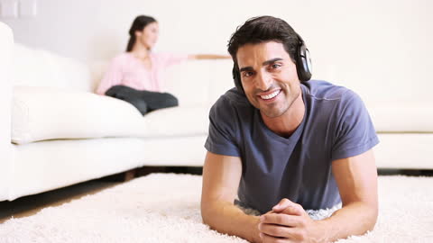 Relaxed Man Smiling While Listening to Music on Comfy Carpet