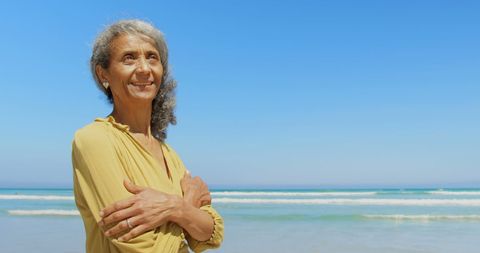 Elderly Woman in Yellow Dress Enjoys Sunny Day at Beach