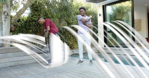 Young men stretching and scootering on poolside deck with modern backyard greenery
