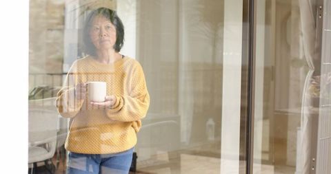 Senior Woman Contemplating Life at Home with Coffee