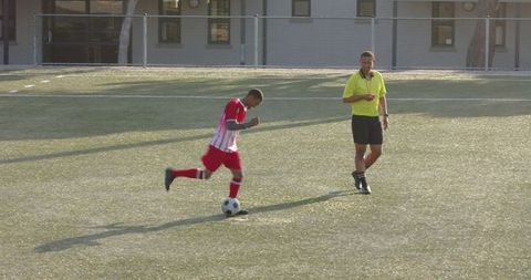 Coach Supervising Young Player During Soccer Practice