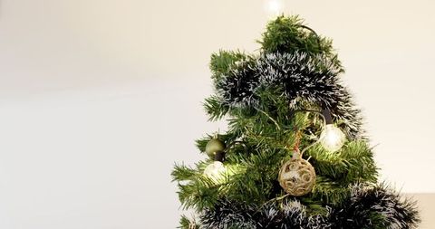 Minimalist Christmas Tree with Tinsel and Golden Ornaments