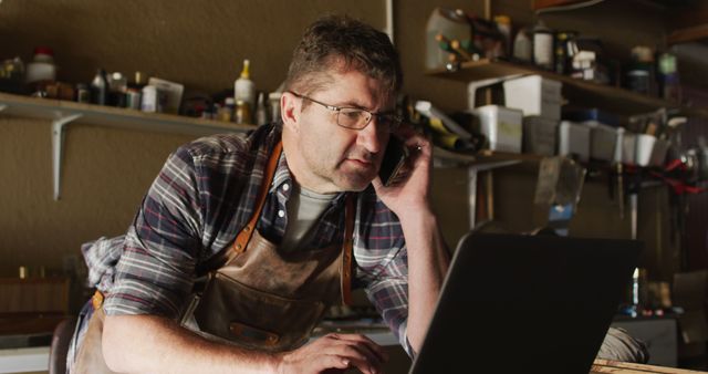 Craftsman Working in Workshop, Talking on Phone and Using Laptop - Download Free Stock Images Pikwizard.com