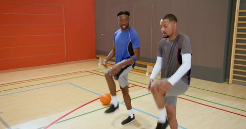 African american men training basketball dribbling and footwork on indoor court