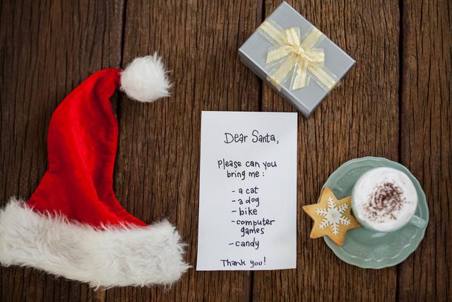 Letter for Santa, gift, coffee and cookie on wooden board