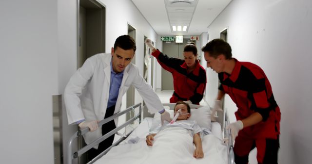 Doctor and nurses transporting patient on stretcher in hospital corridor, ideal for illustrating medical emergencies, healthcare teamwork, critical conditions, and urgent care scenarios.