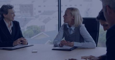 Blonde executive leading boardroom meeting, discussing strategy with team in urban office