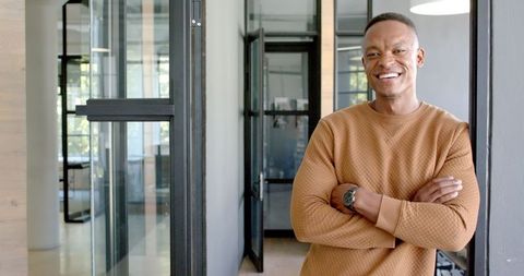Confident Businessman Smiling in Modern Office Hallway