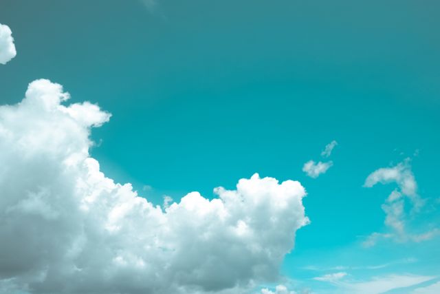 Depicts fluffy white clouds against a vibrant blue sky, evoking feelings of peace and tranquility. Ideal for backgrounds, inspirational posters, nature-themed designs, and weather-related content.