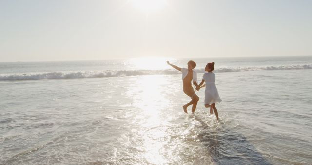 Joyful Couple Splashing in Ocean at Sunset - Download Free Stock Images Pikwizard.com