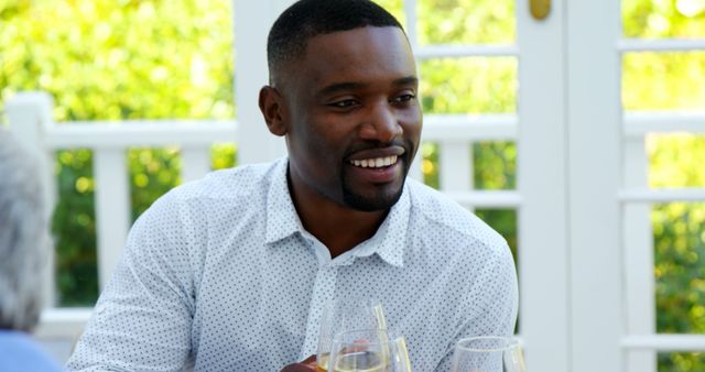 Smiling Man Enjoying Outdoor Dining with Wine Glasses - Download Free Stock Images Pikwizard.com