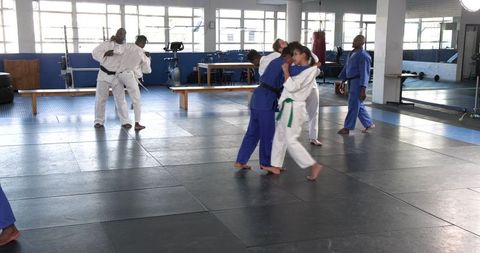 Teen Girls Practicing Judo Techniques in Gym