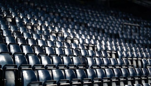 Empty blue stadium seats repeating diagonal pattern reflecting light for sports design