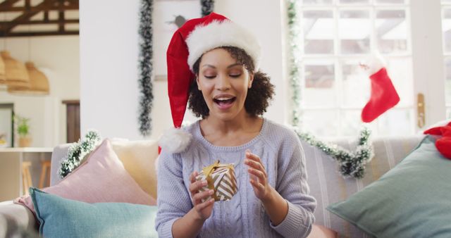 Portrait of happy african american woman with santa hat having image call. Spending quality time at christmas alone concept.