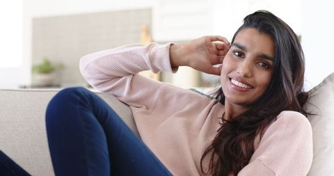 Relaxed Indian Woman Reclining on Sofa at Home in Comfortable Attire