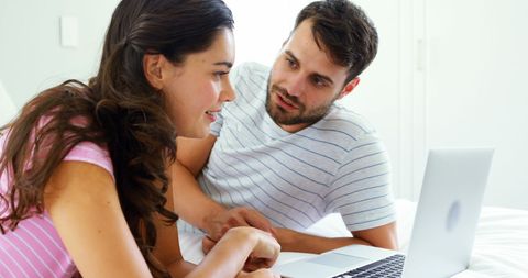 Couple Collaborating on Laptop in Cozy Bedroom