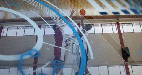 Basketball tipoff jumping players reaching for ball while referee tossing in indoor gym