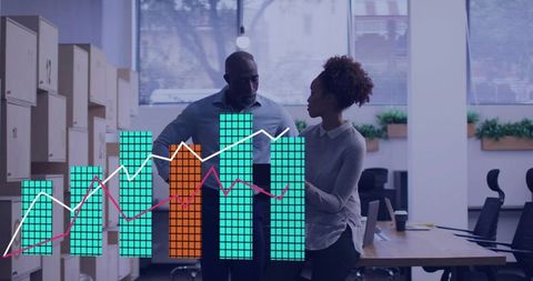 Collaborating over data visualization in modern open-plan office with colorful bar chart