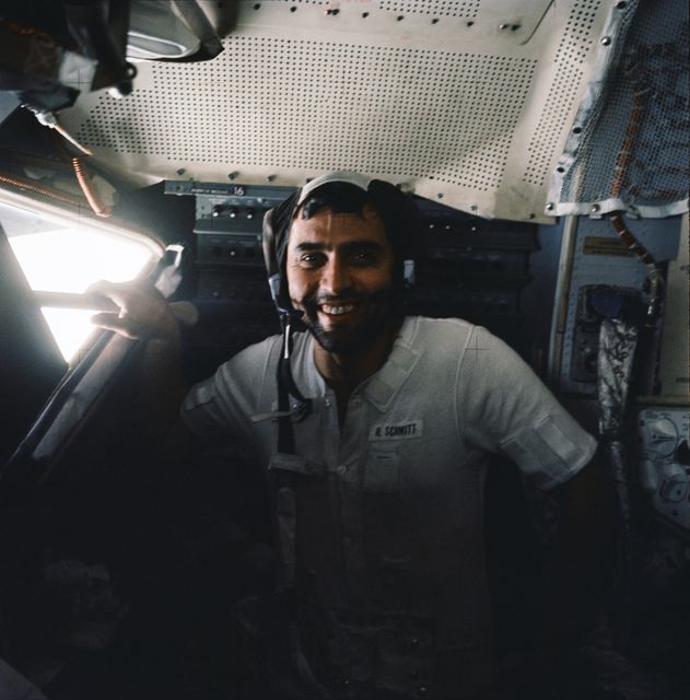 The photograph captures astronaut Harrison H. Schmitt inside the Lunar Module during the Apollo 17 mission in December 1972. The image depicts him sporting several days of beard growth, reflecting the long duration in space. This historical image can be used in educational materials, articles about space exploration, commemorative pieces related to NASA missions, or for illustrating human aspects of space travel.