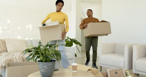 Diverse Couple Decorating Living Room with Moving Boxes and Plant