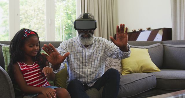 Grandfather and granddaughter using virtual reality headset at home - Download Free Stock Images Pikwizard.com