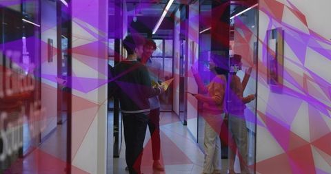 Coworkers Discussing Project in Modern Glass Office Corridor