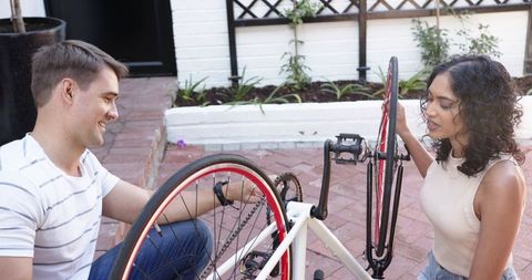 Couple collaborating on bicycle repair outdoors