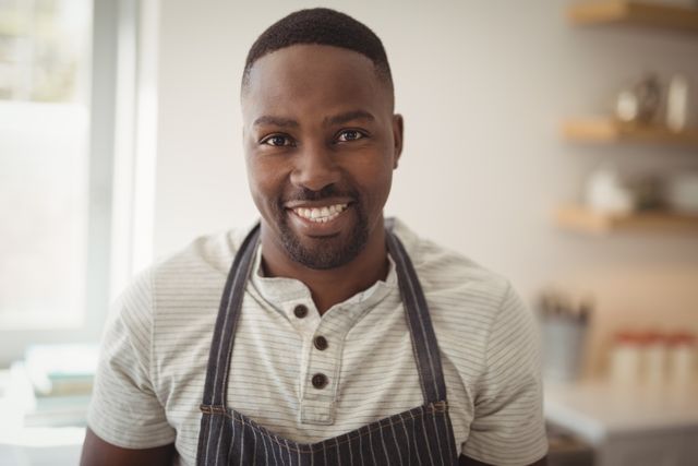 Portrait of smiling man standing in kitchen at home