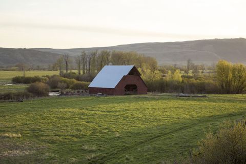 Scenic Rural Barn at Sunset in Lush Green Pasture