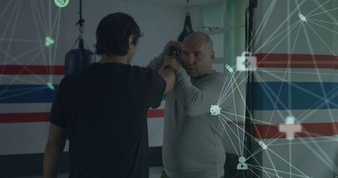 Coach teaching weapon retention drill in boxing gym with tech overlay for self-defense