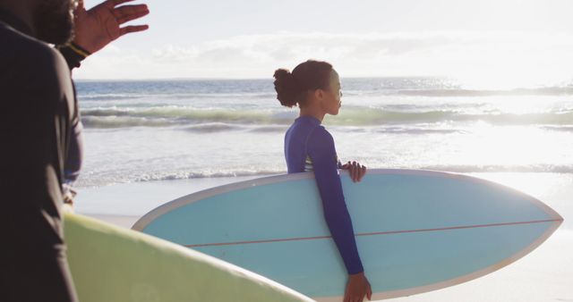 Young woman carrying surfboard at sunny beach - Download Free Stock Images Pikwizard.com