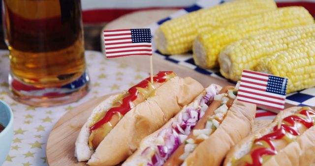Scene showcasing a classic American 4th of July BBQ celebration. Hot dogs with ketchup, mustard, and onions are garnished with small American flags, accompanied by corn on the cob. Perfect for depicting American holidays, family gatherings, summer events, or food-related promotions.